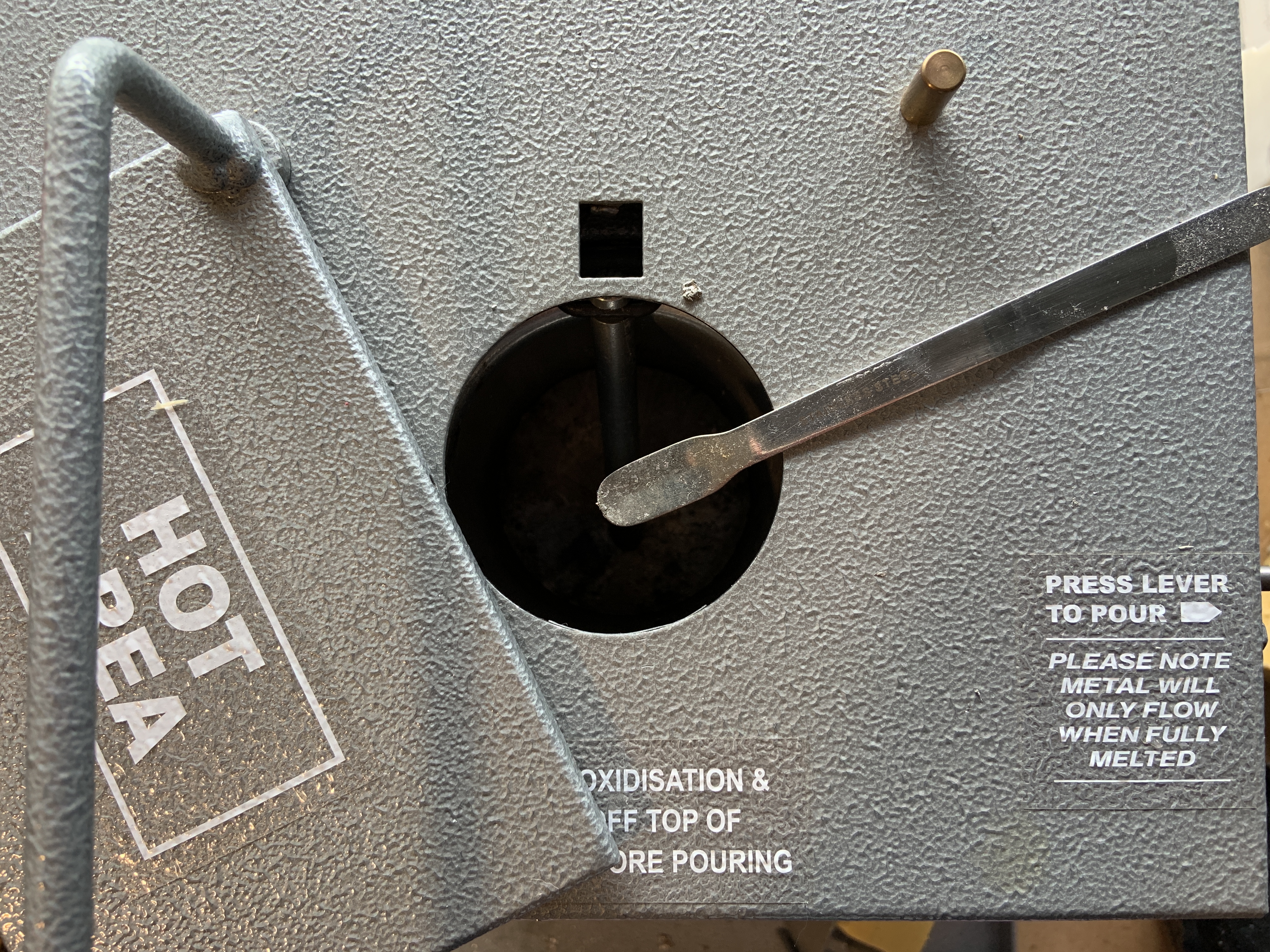 Scrape scum off pewter crucible